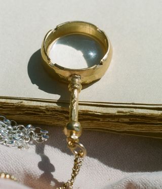 golden magnifying glass on chain