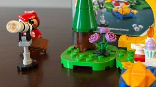 Lego Celeste minifigure looking into a telescope beside a tree and flower set