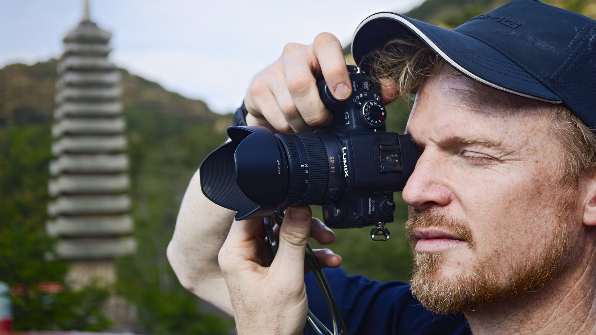 Man holding the Panasonic Lumix G1 mirrorless camera's viewfinder up to his eye