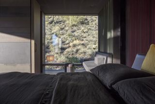 The bedroom with views out to the desert terrain