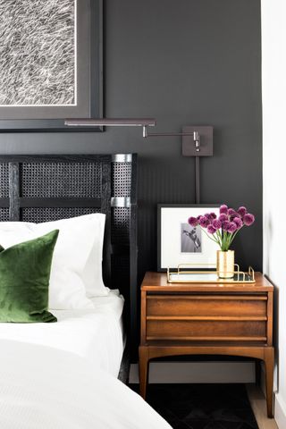 a grey bedroom with a wooden nightstand