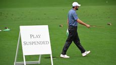 Scottie Scheffler walks off the course after play is suspended in a Masters practice round