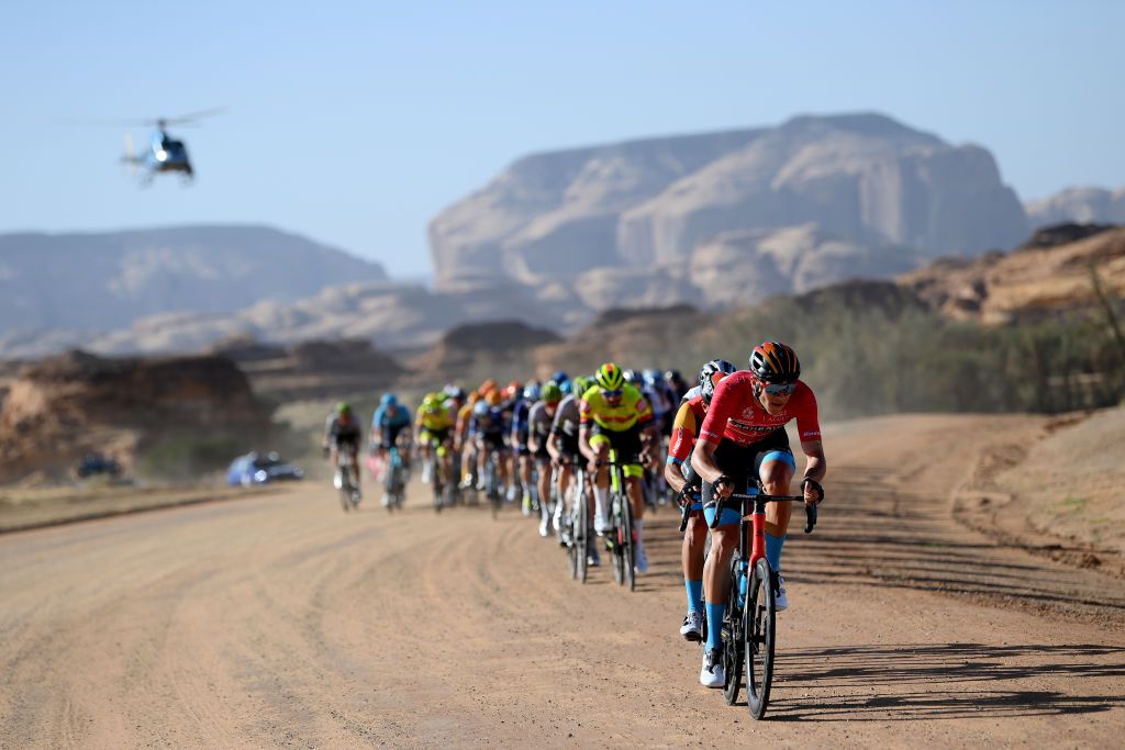 Jonathan Milan leads the Saudi Tour peloton on the gravel