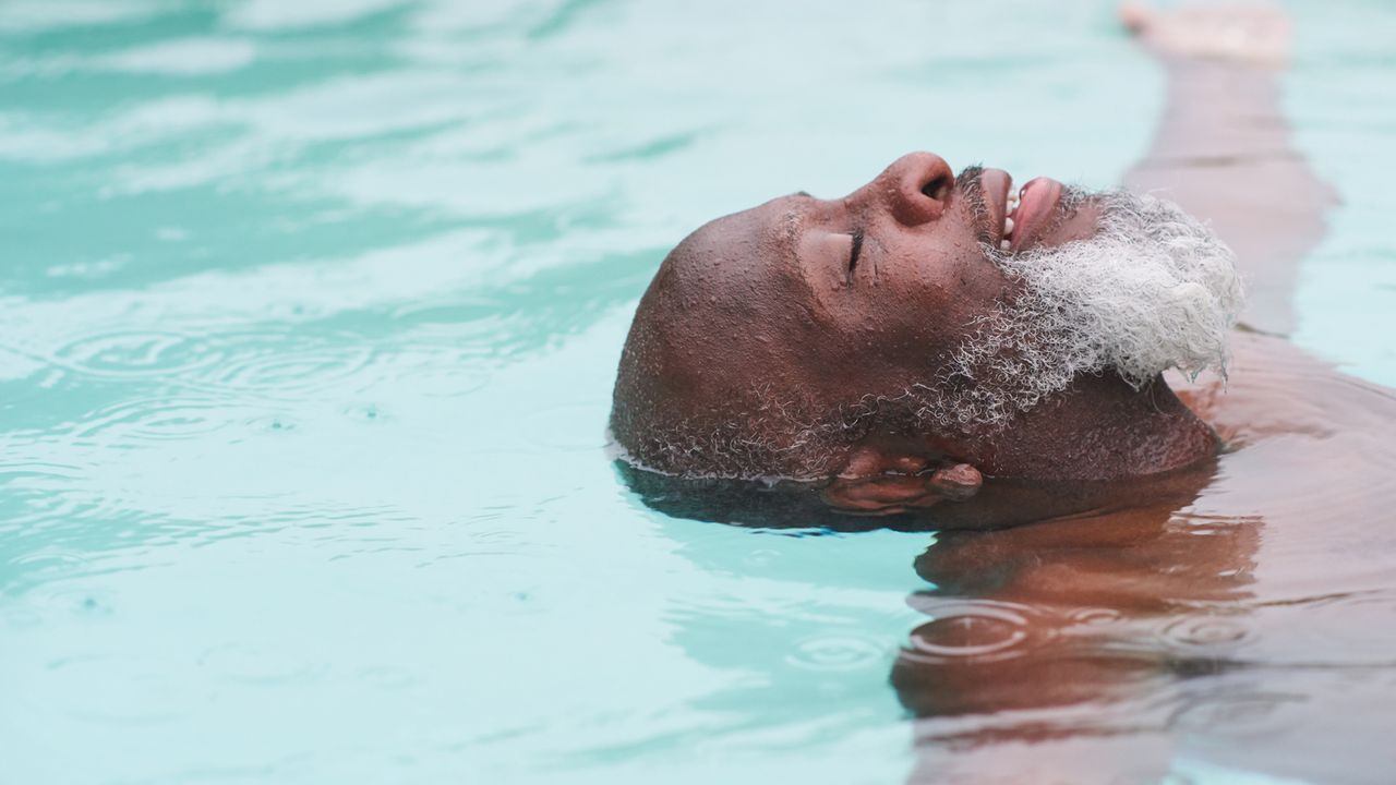 Man swimming on his back and smiling