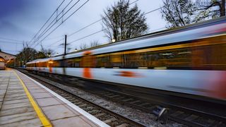 Train moving very fast past the camera, which is held on a station platform