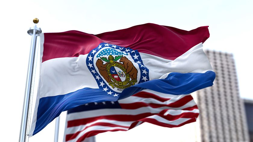 Flag of Missouri flying on a cloudy day with the US flag flying behind it