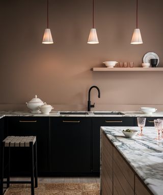 3 small white glass pendant lights hung above kitchen worktop with inset sink and black tap