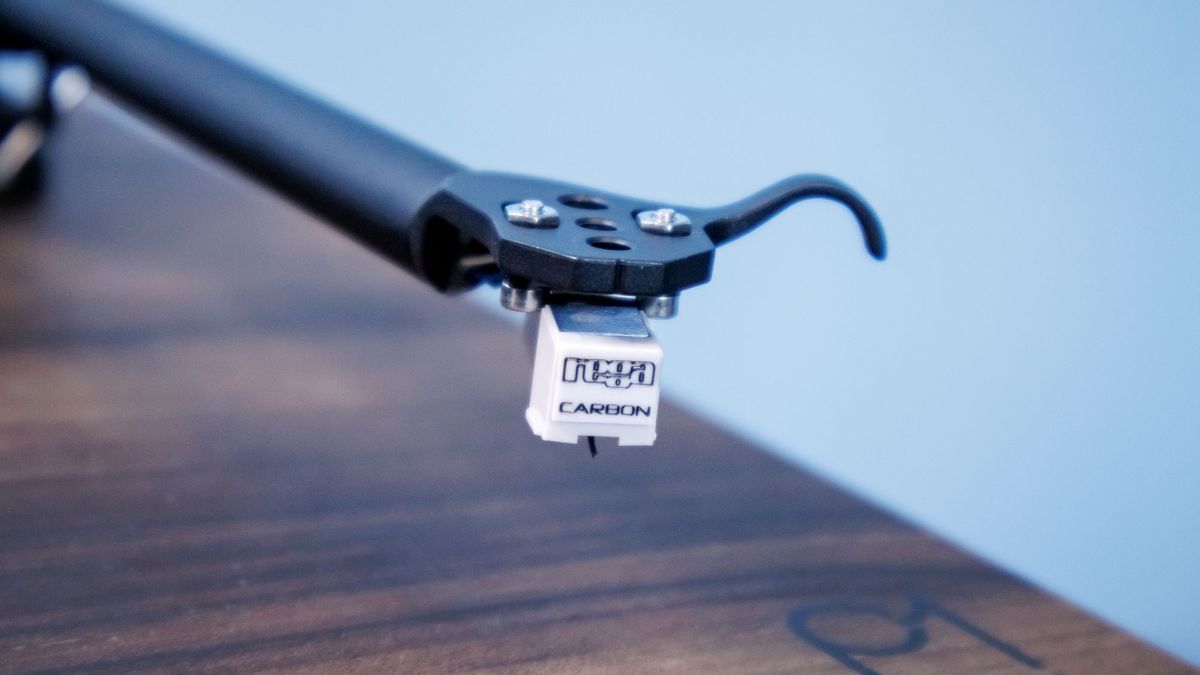 A closeup of the Rega Carbon cartridge at the end of the tonearm on a Rega Planar 1 Plus turntable