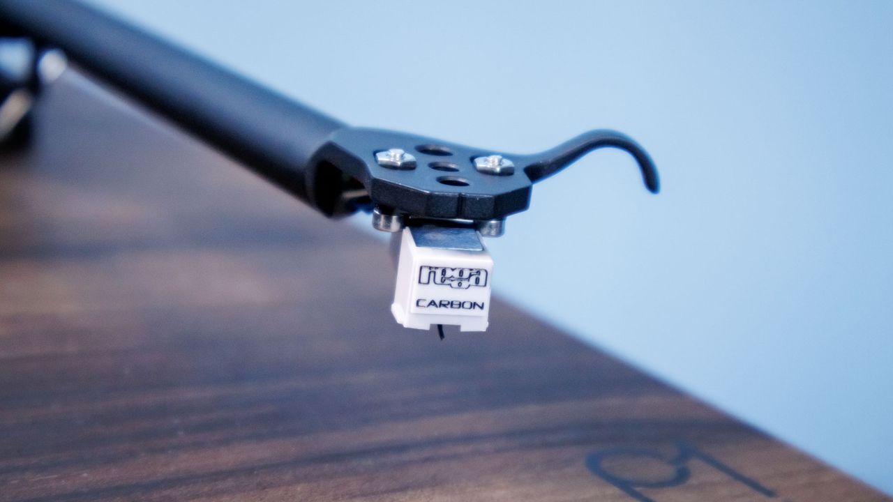A closeup of the Rega Carbon cartridge at the end of the tonearm on a Rega Planar 1 Plus turntable