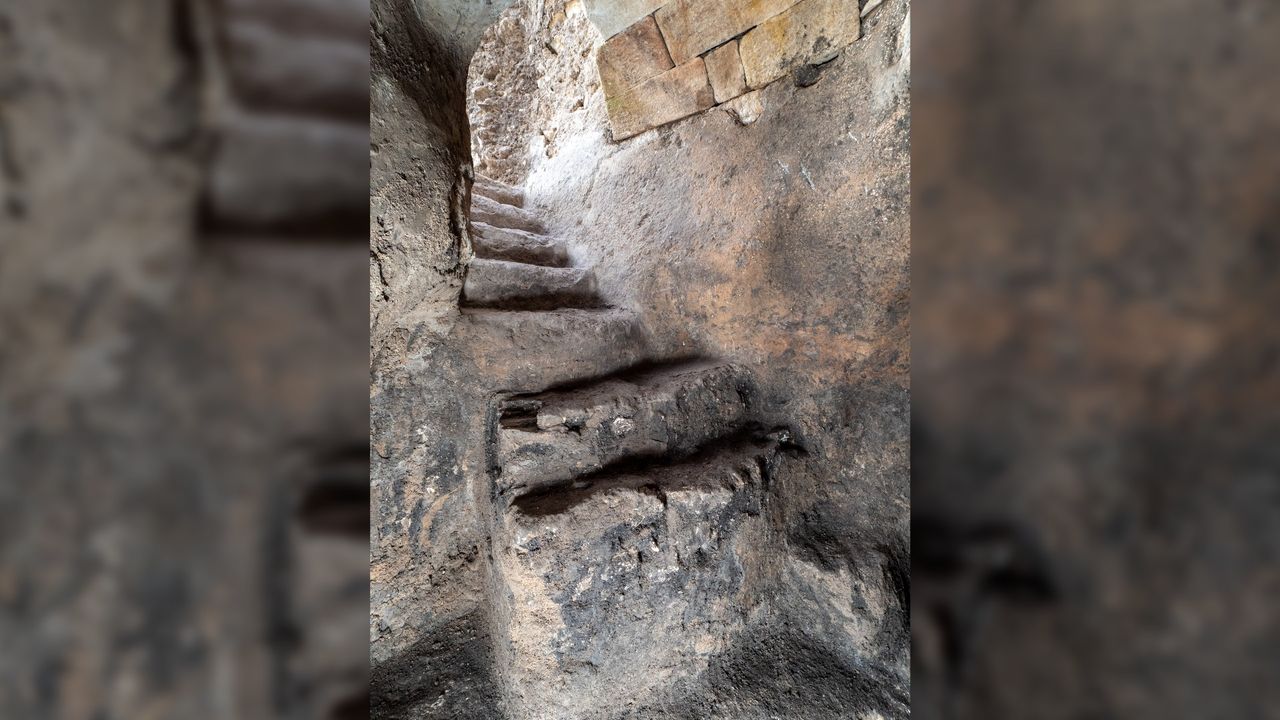 A set of uneven stone steps leading up to an opening at the top.