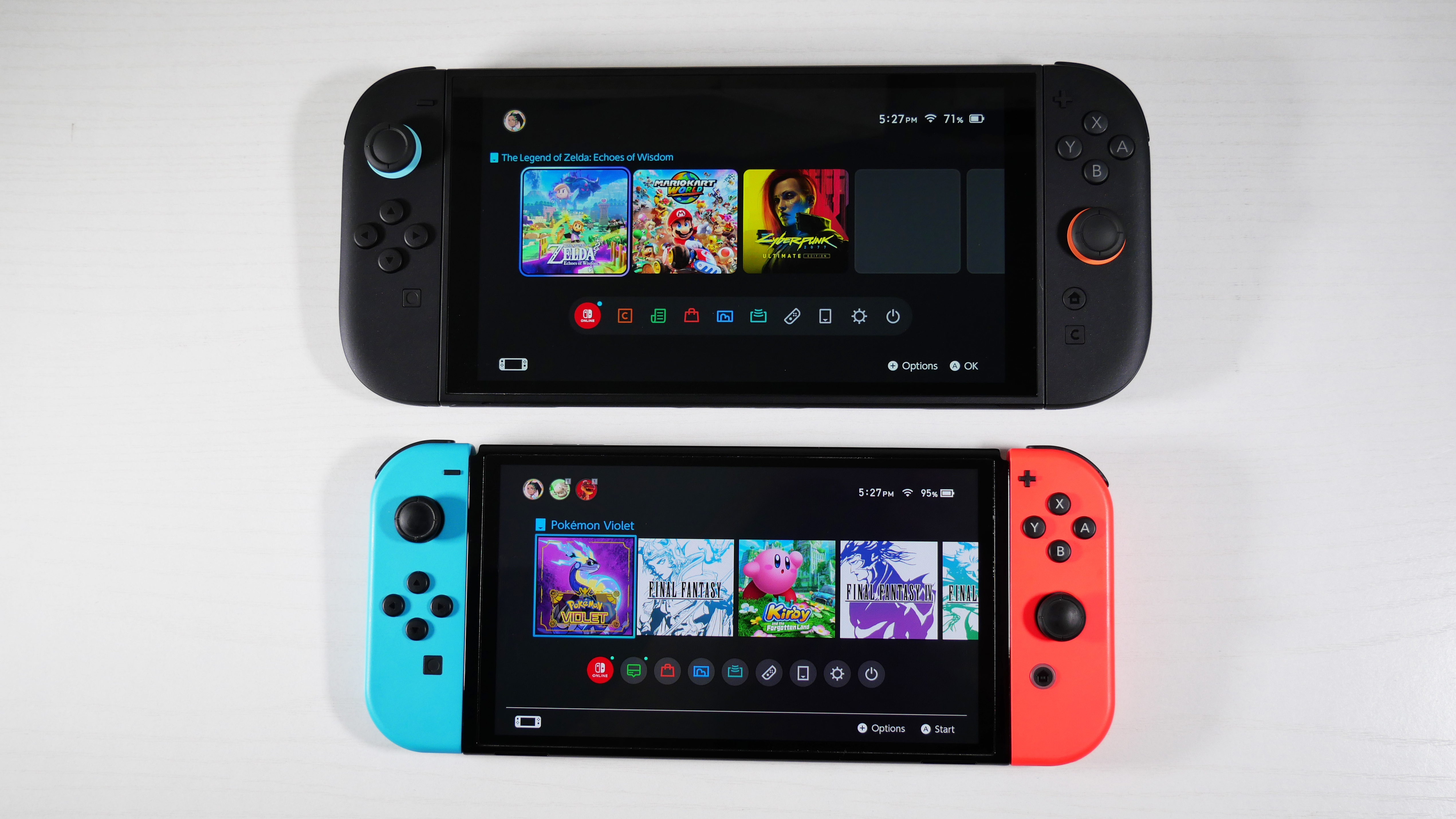 Nintendo Switch 2 and Switch OLED on a white desk, stacked on top of one another.
