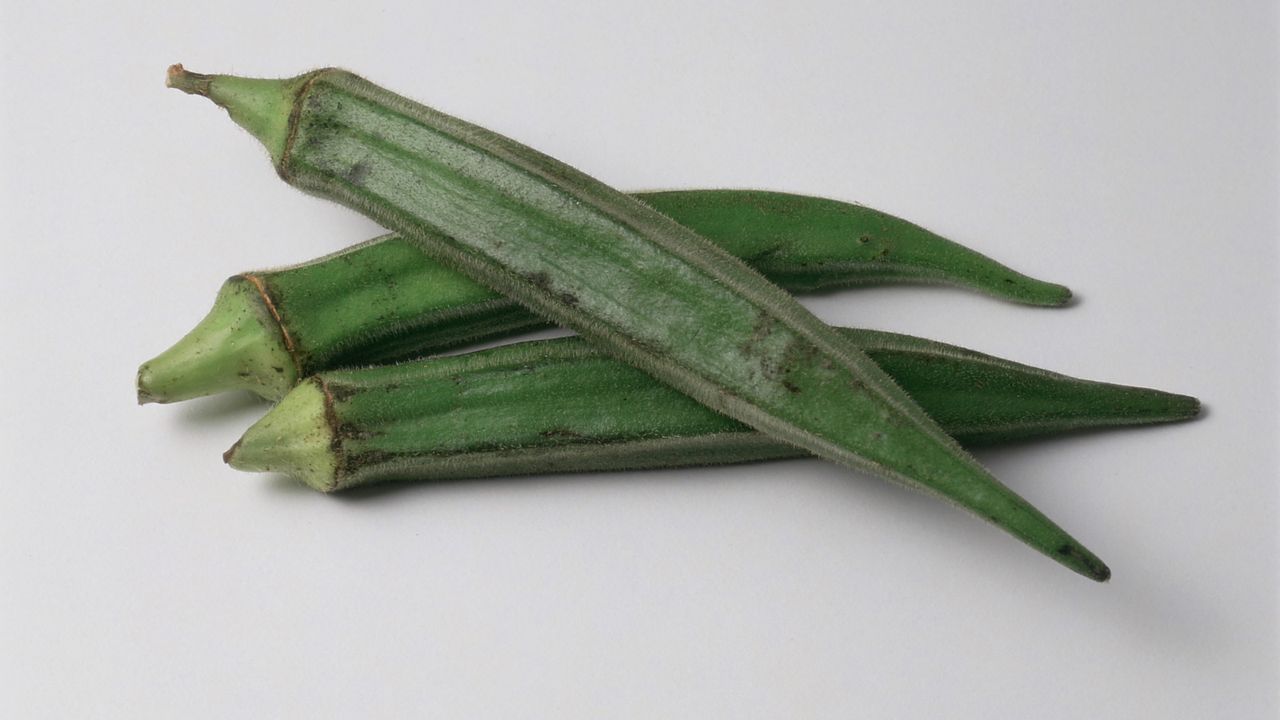 Three green okra pods on a white background