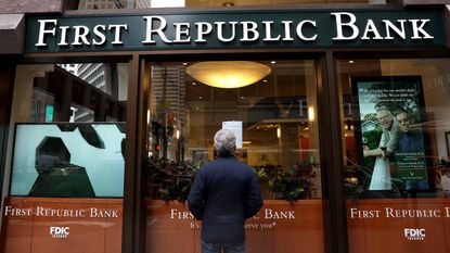 person standing outside of First Republic Bank reading FDIC notice