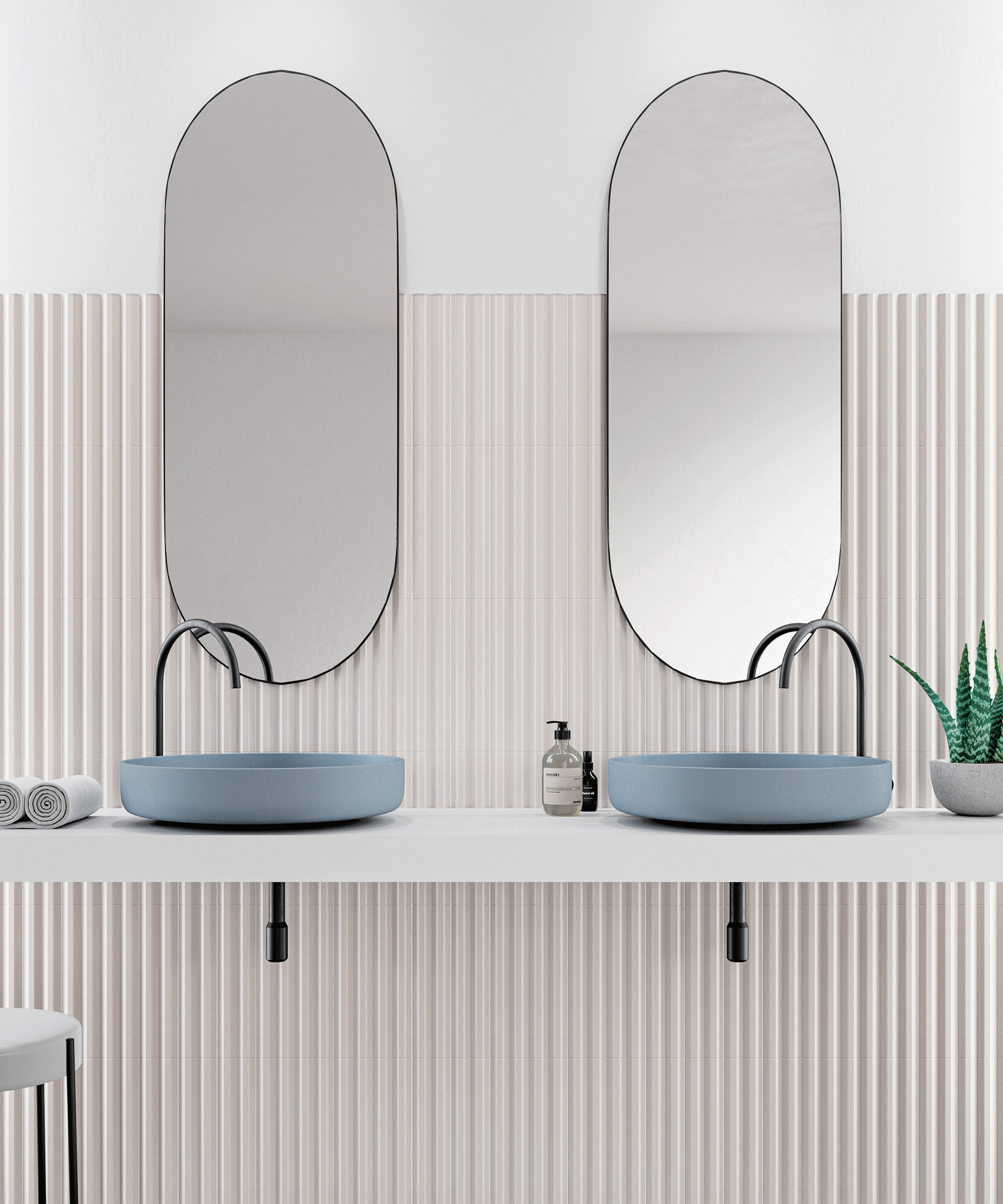A double bathroom vanity with blue sinks in front of symmetrical mirrors and a ribbed wall