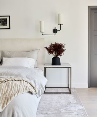 neutral bedroom with a contemporary wall sconce above the nightstand