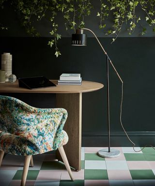 small home office with dark green walls and patterned desk chair