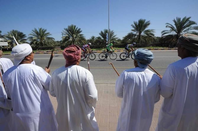Locals watch the break pass on the final day of the Tour of Oman.