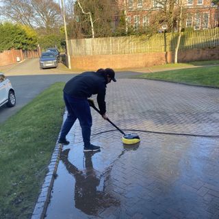 man using Karcher K7 smart pressure washer with surface cleaner head on a driveway