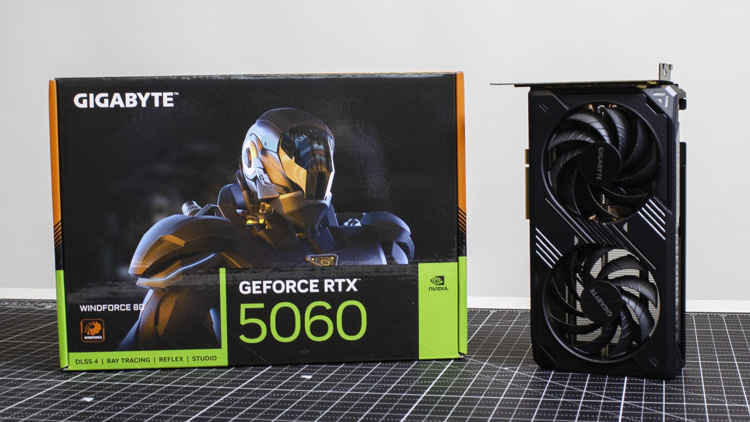 A Gigabyte GeForce RTX 5060 on a desk in front of its retail packaging