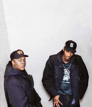 Portrait of two men in baseball caps from pages of Rapper's Deluxe