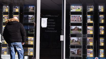 Man looking in an estate agent's window