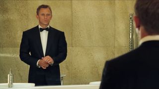 Daniel Craig adjusts his tuxedo cuffs in the mirror in Casino Royale.