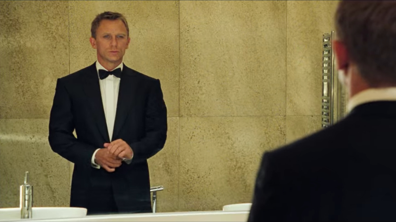 Daniel Craig passt seine Smoking-Manschetten im Spiegel in Casino Royale an.