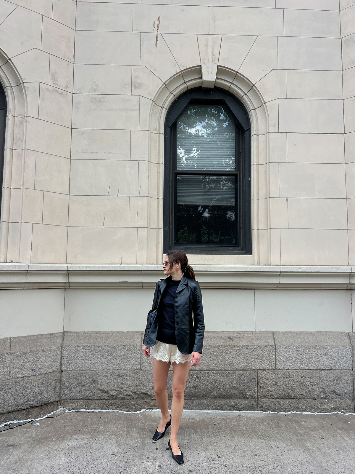 Eliza Huber wearing lace-trim shorts with a leather blazer and flats.