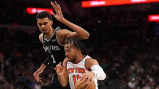 Jalen Brunson of the New York Knicks dribbling the ball past Victor Wembanyama of the San Antonio Spurs