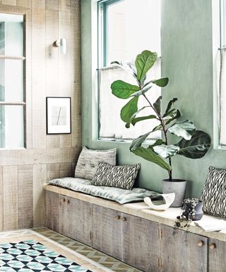 window bench with cushions and large houseplant