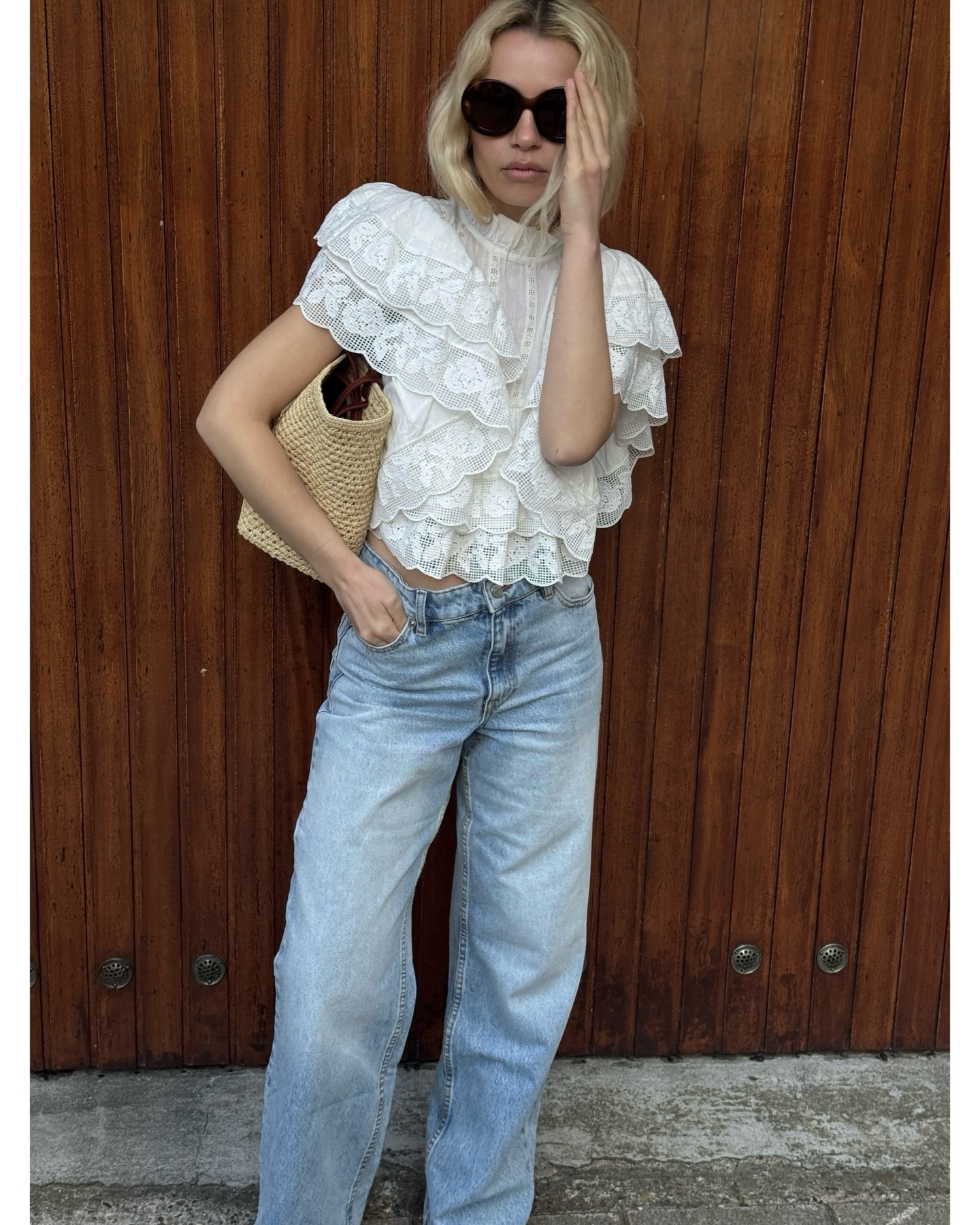 An image of a woman wearing a blouse and jeans summer outfit 2026