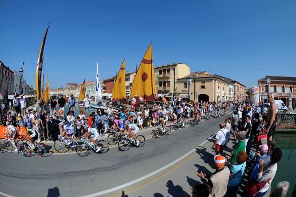 The peloton is cheered on by many spectators.