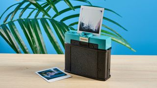 A black and teal Lomography Diana Instant Square instant camera