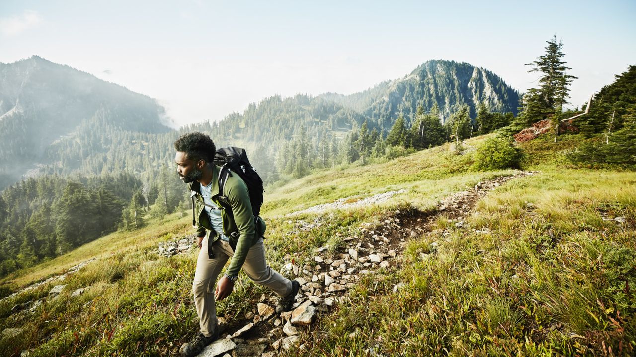 Man on early morning hike up mountainside