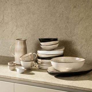 Stoneware cup among matching plates, bowls and more on worktop