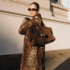 @darjabarannik wearing a leopard calf-hair coat and carrying a brown suede handbag