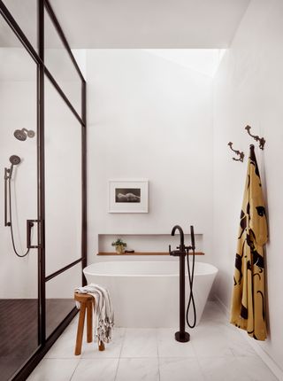 A bathroom with hooks and a bath side table