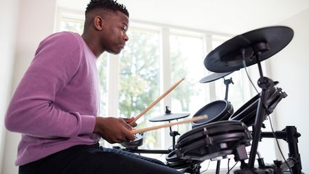 Young man plays an electronic drum set