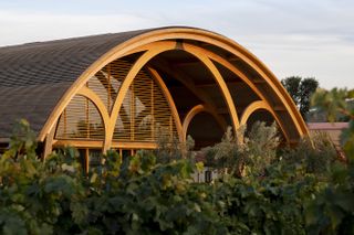 Bodegas Faustino Winery seeing its rounded roof and ceiling, The design reinterprets the winery as a whole andcreates a stronger connection between theexisting cellars and the surrounding vineyard