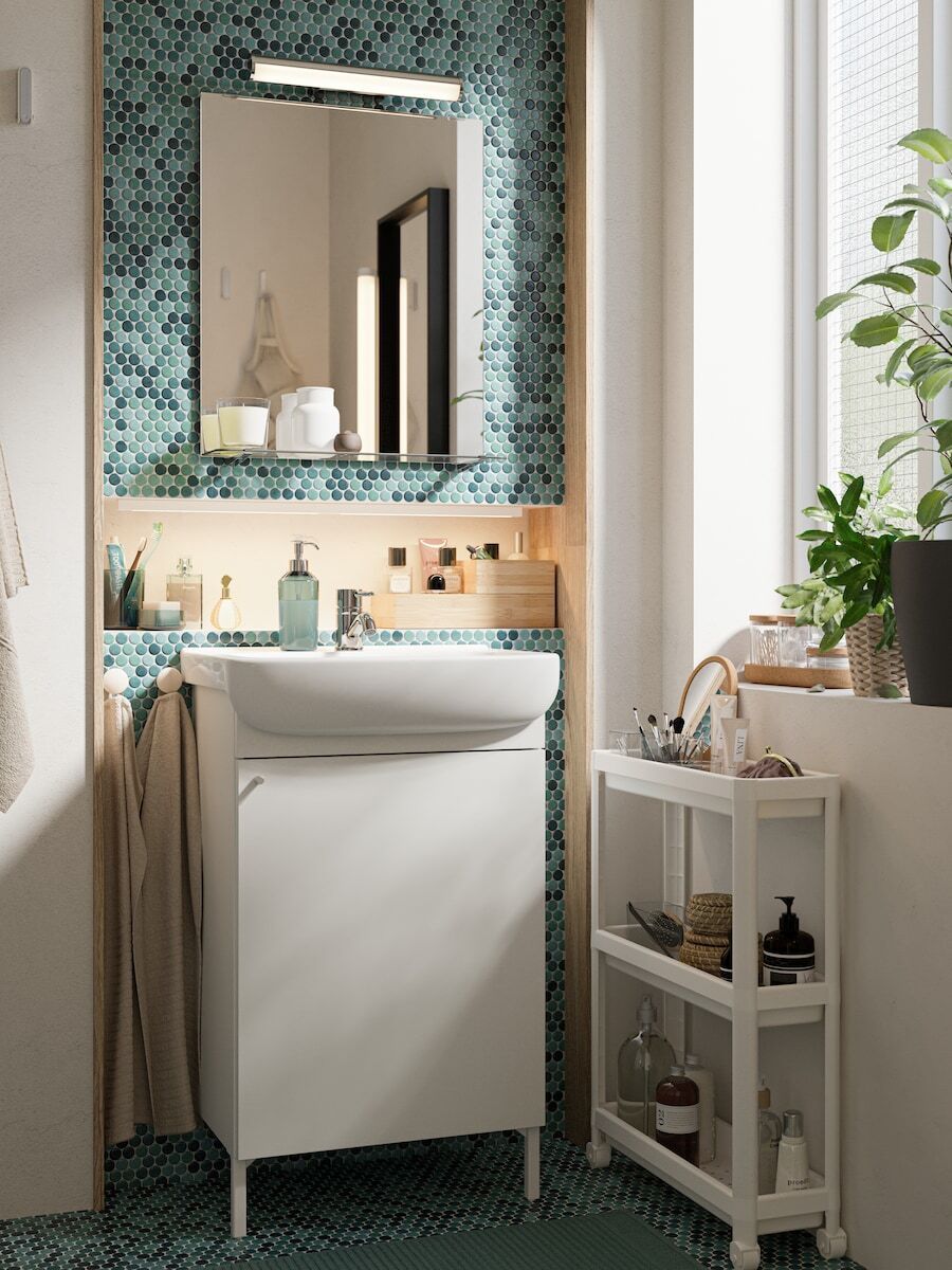 Bathroom with small dressing table with blue and green tiled background