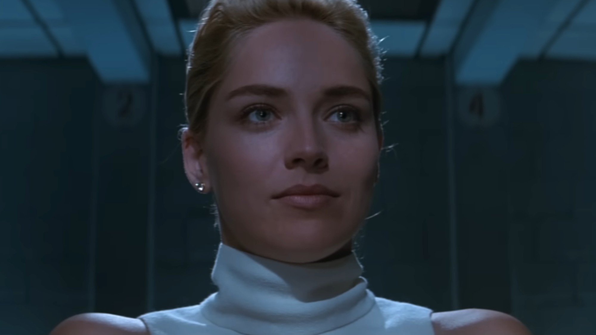 A close up of Sharon Stone in a white turtleneck in the interrogation scene in Basic Instinct.
