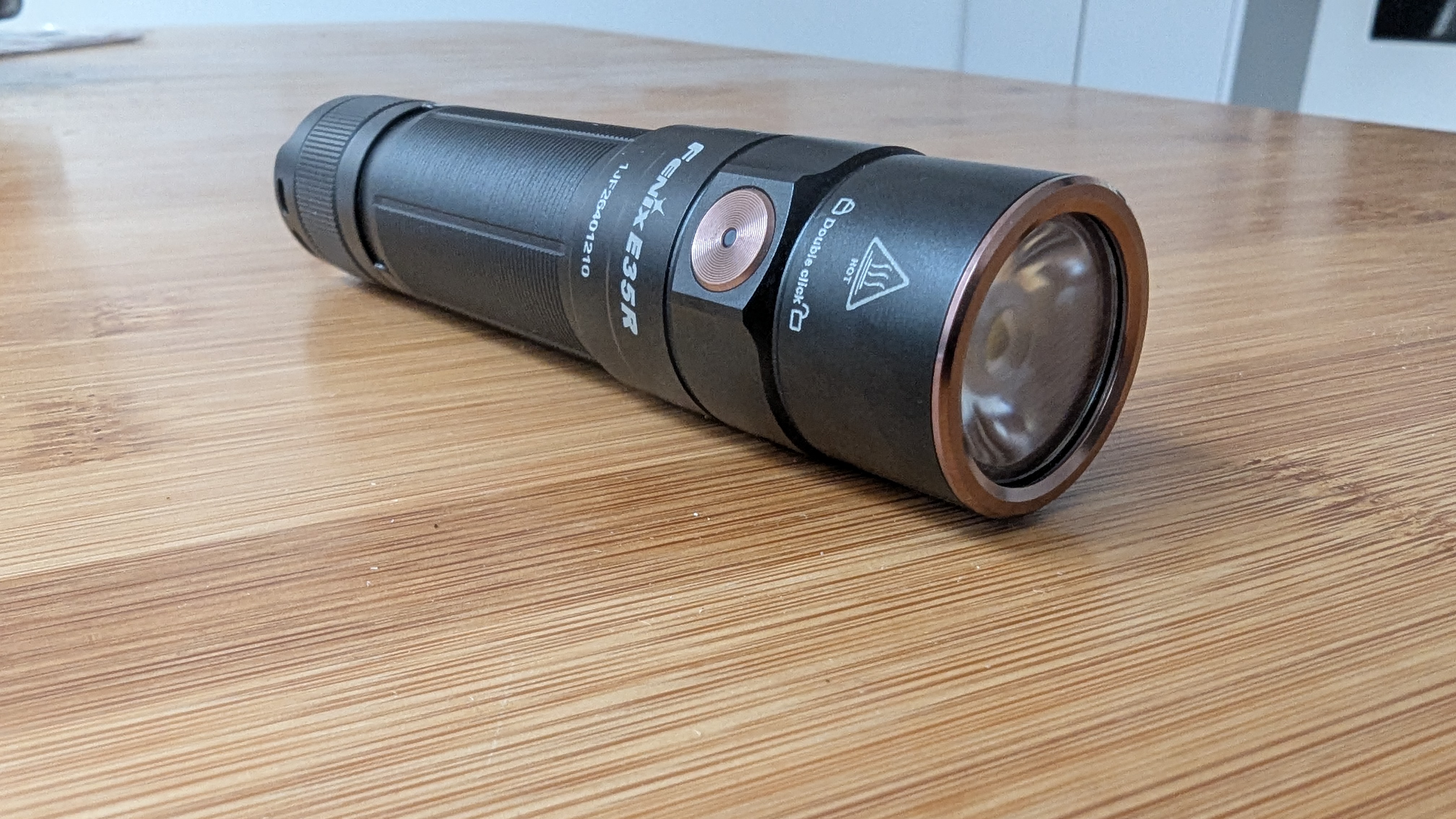 Fenix E35R flashlight during review with the bulb and copper surround closest to the camera