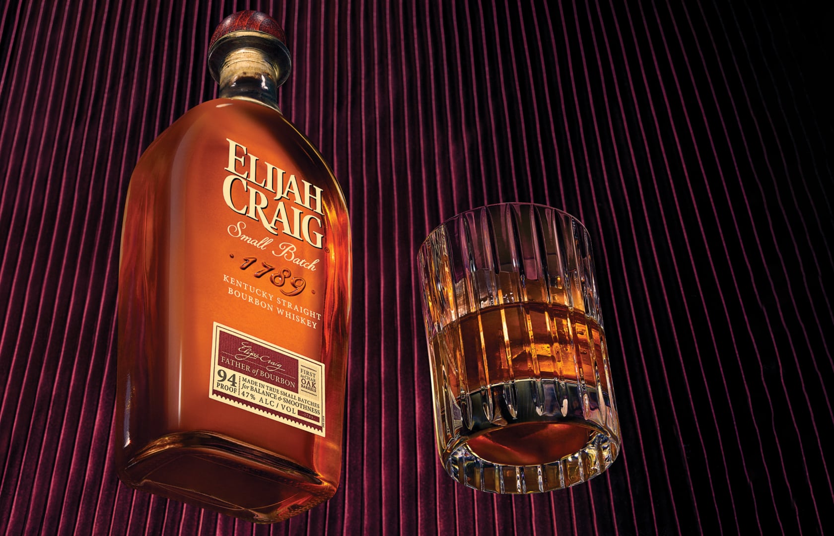 A bottle of Elijah Craig with an Old Fashioned cocktail
