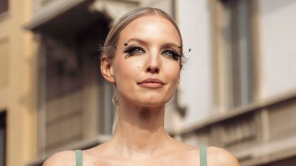 How to apply false eyelashes - woman photographed on the street with elaborate feathery false eyelashes - getty1469005529
