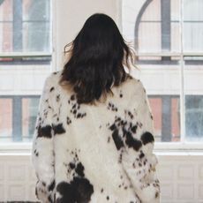 A model wearing a cream-and-brown faux fur animal print coat from Zara.