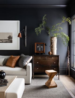 Black living room with white sofa and natural materials