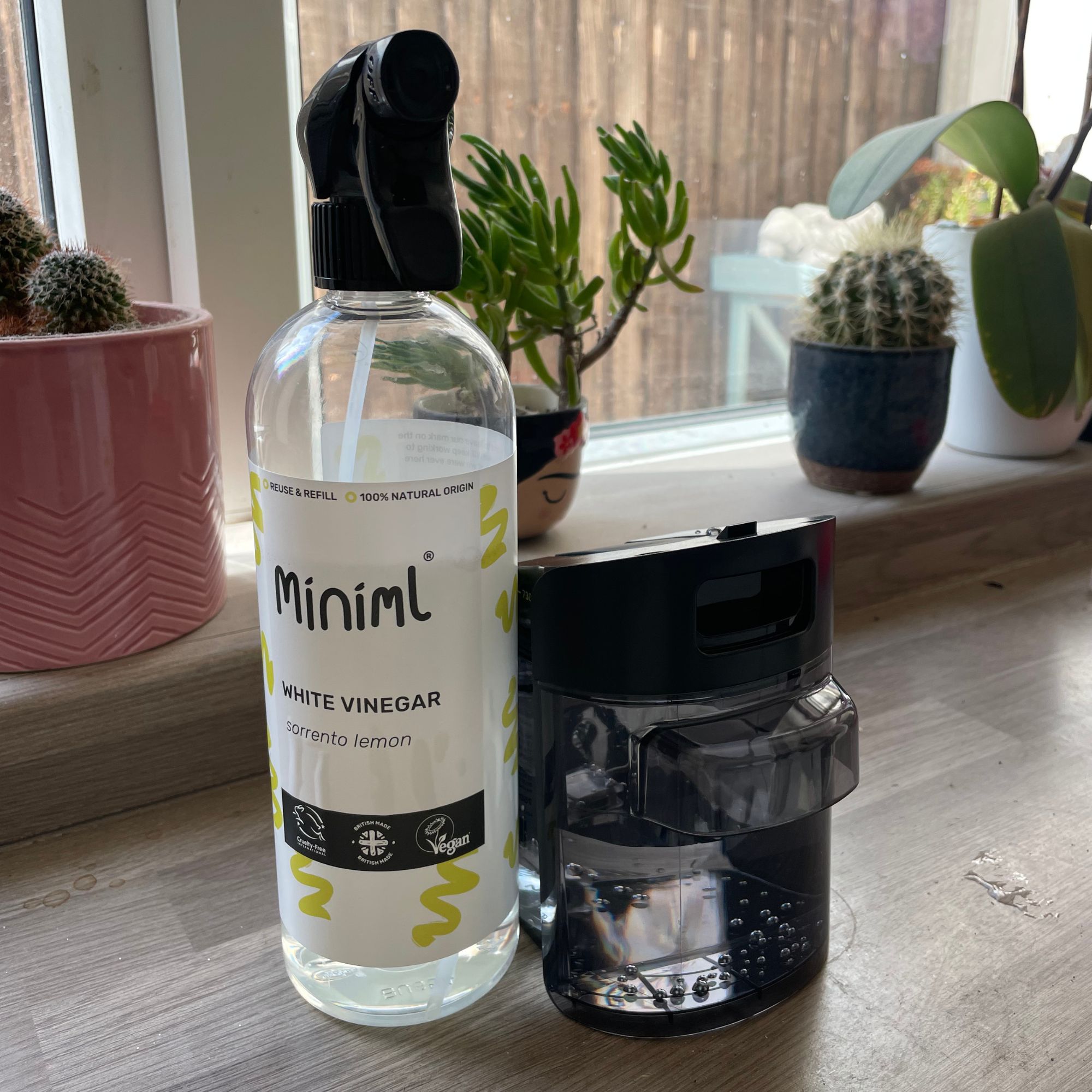 Bottle of white vinegar and a container of water sitting on kitchen worktop