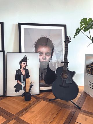 Artist in residence; a guitar stood against paintings