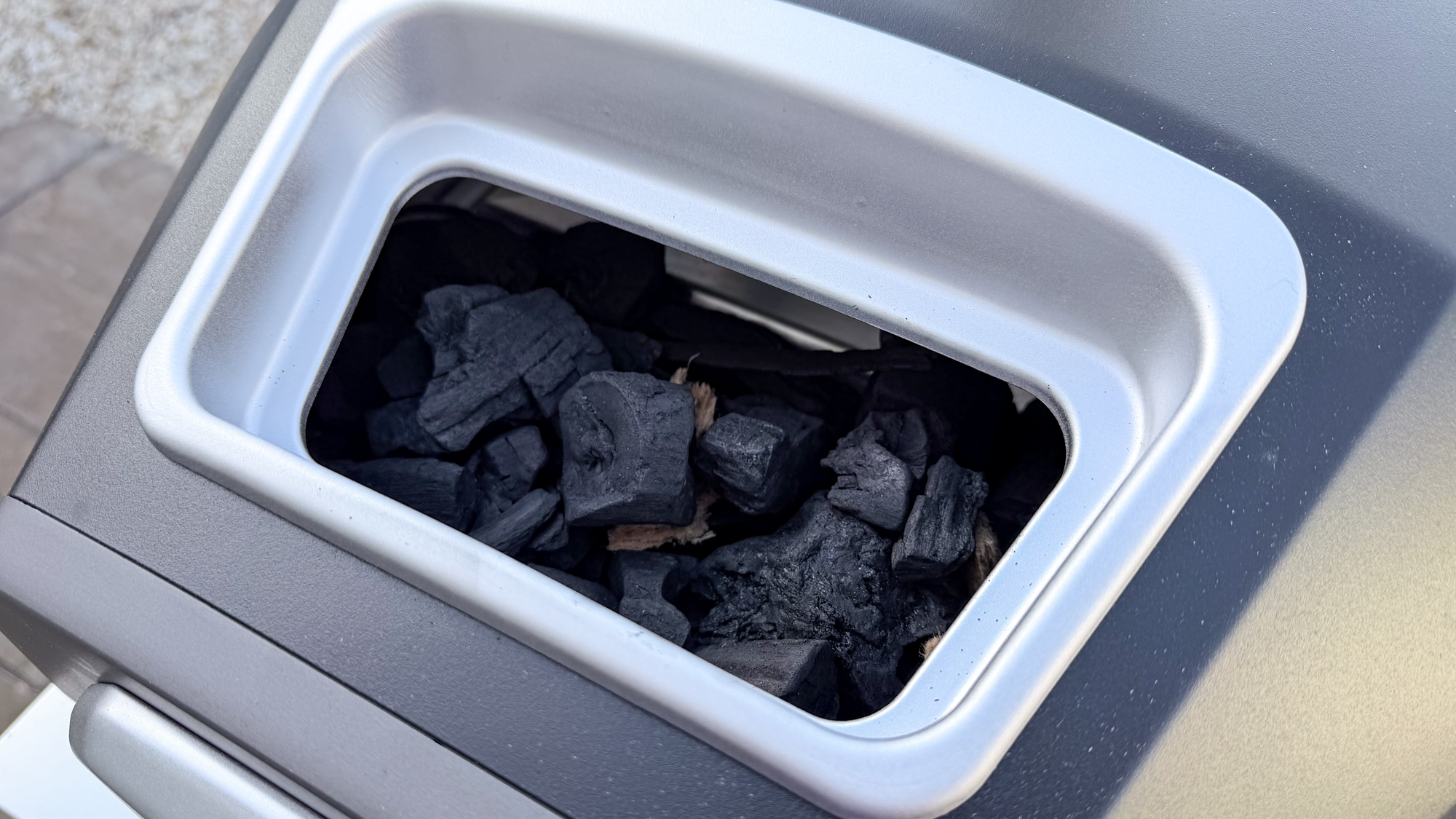 Ooni Karu 2 pizza oven fuel hatch open with charcoal placed inside