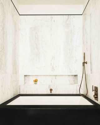 Marble bathroom with white wash basin and copper shower and tap fittings